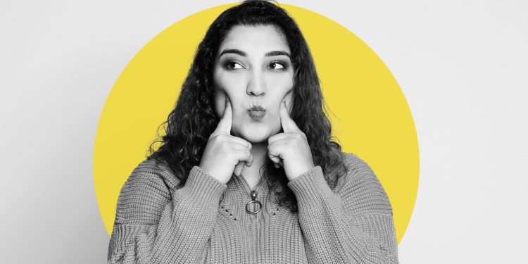 Teenage girl making fish lips, studio shot